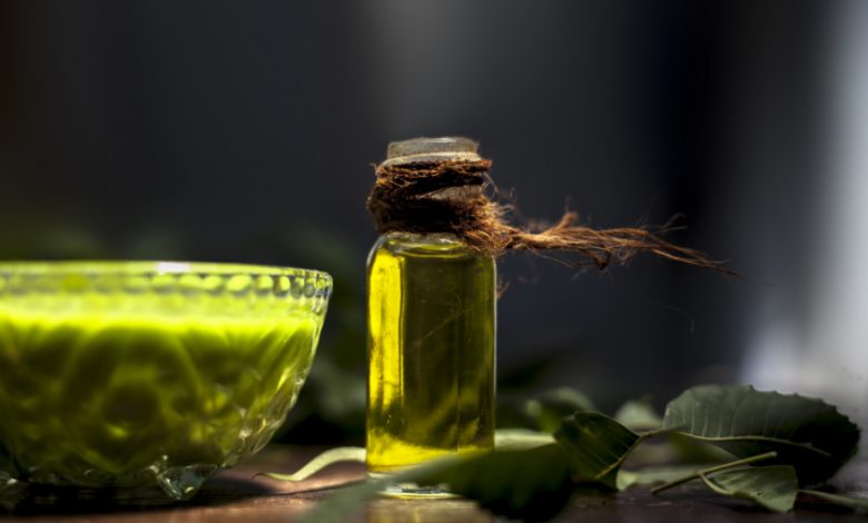 Hair remedy of all-purpose ayurvedic medicinal herb i.e. Neem or Nim or Indian lilac in a glass bowl along with neem leaves, freshwater & tea tree oil for dandruff or hair skin itching problems. | Aldar.ma